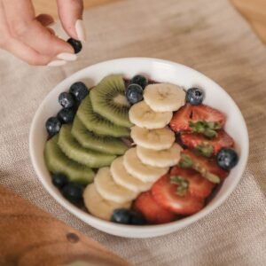 A delicious and healthy fruit bowl featuring kiwi, banana, strawberries, and blueberries. Perfect for a fresh breakfast.